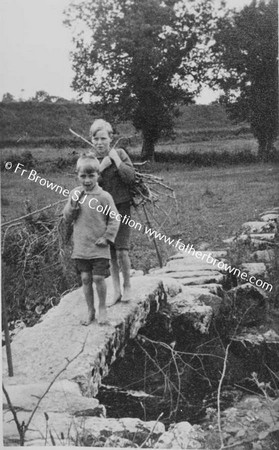 BOYS ON STONE BRIDGE  WITH FIREWOOD